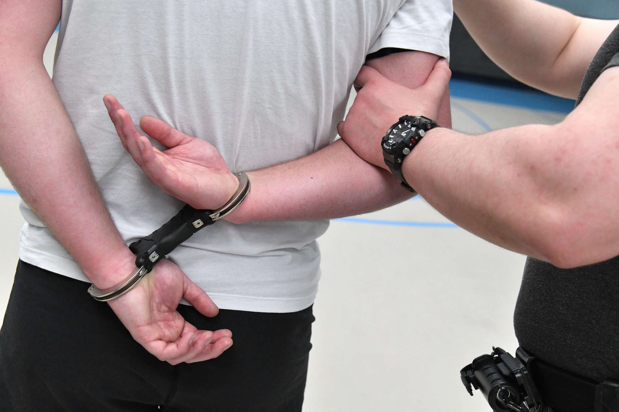 Back of handcuffed man being held by the arm by a special constable